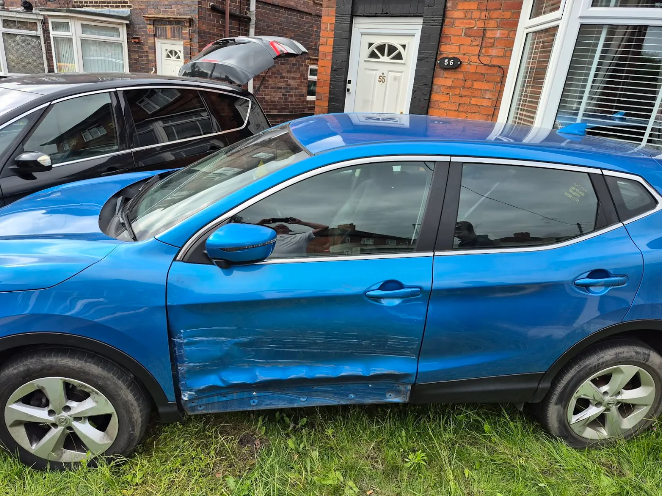 Blue car with significant door and sill damage